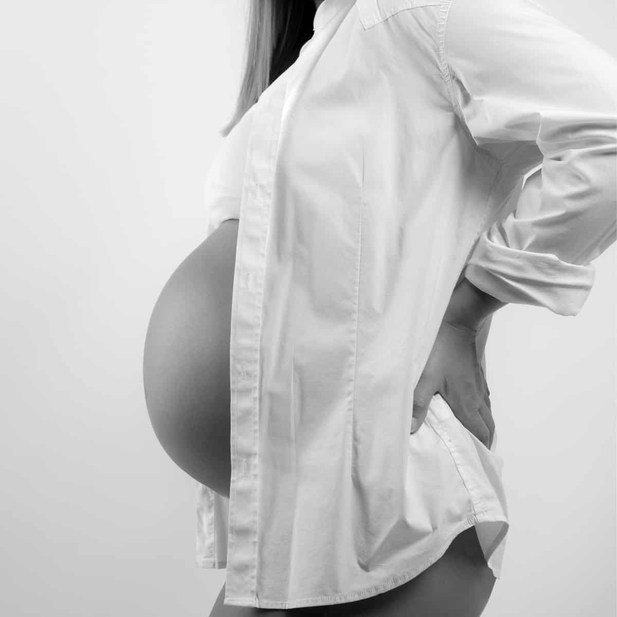 silhouette-of-pregnant-belly-with-white-shirt-draped-down-sides