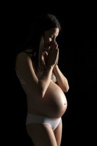 Praying pregnant mother