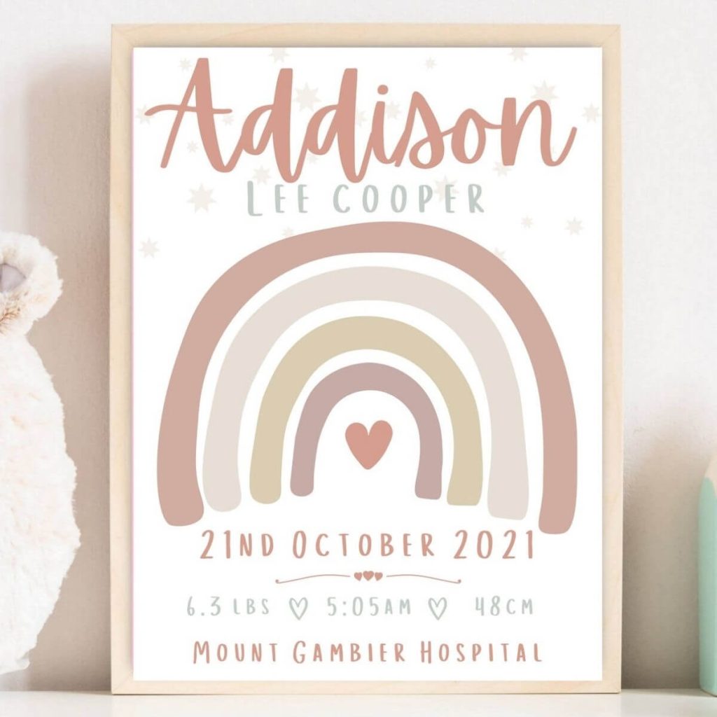 Framed poster-sized print of a soft, pastel colored rainbow that says Addison at the top and has baby's birth stats on the bottom