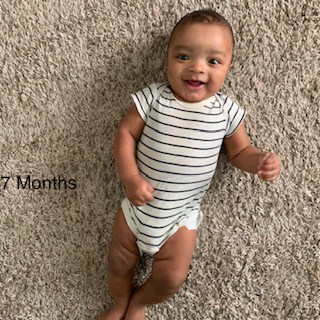 baby-boy-lying-on-carpet-smiling