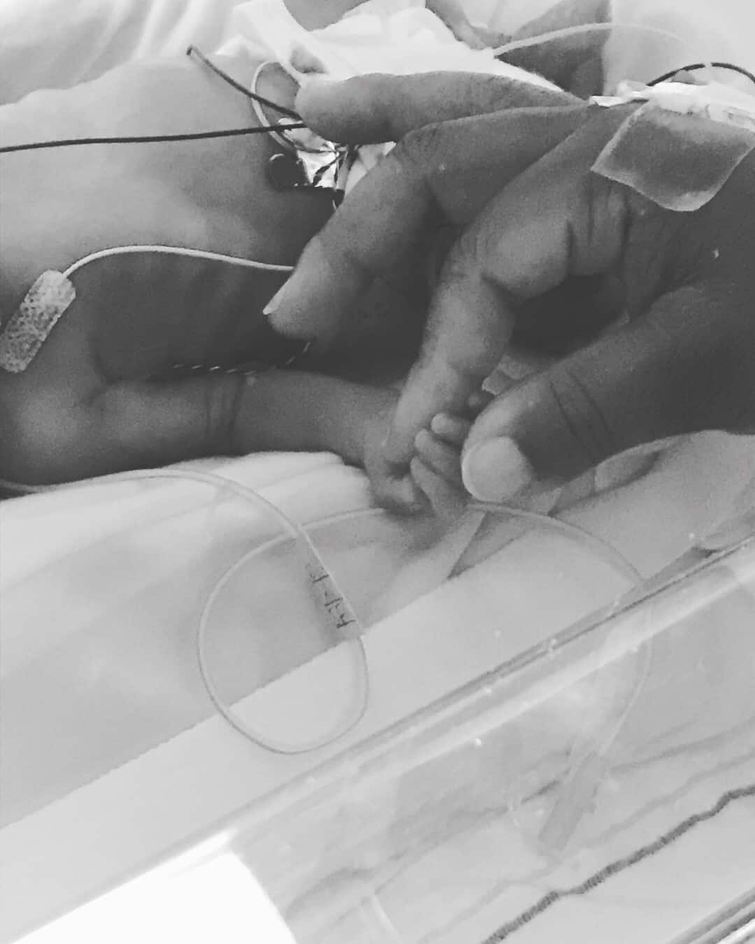 tiny nicu baby hand-holding moms larger hand