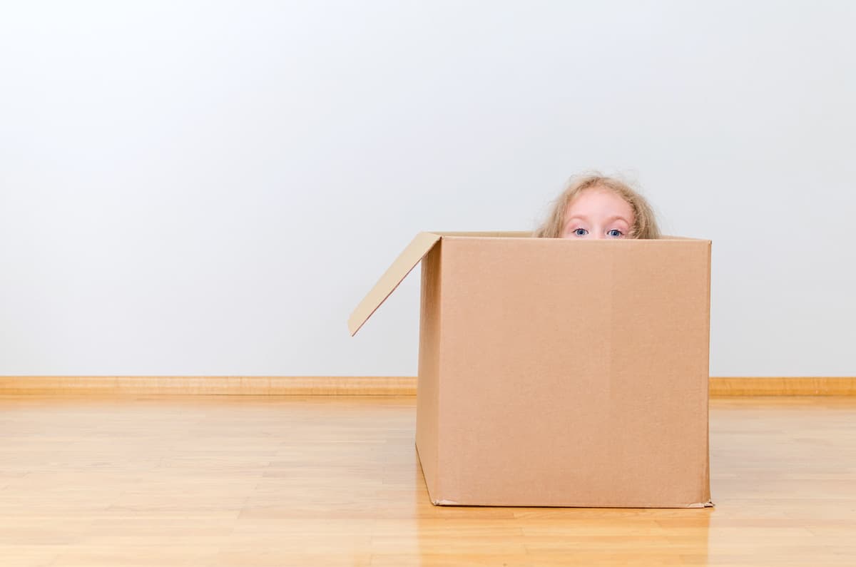 child hiding in moving box