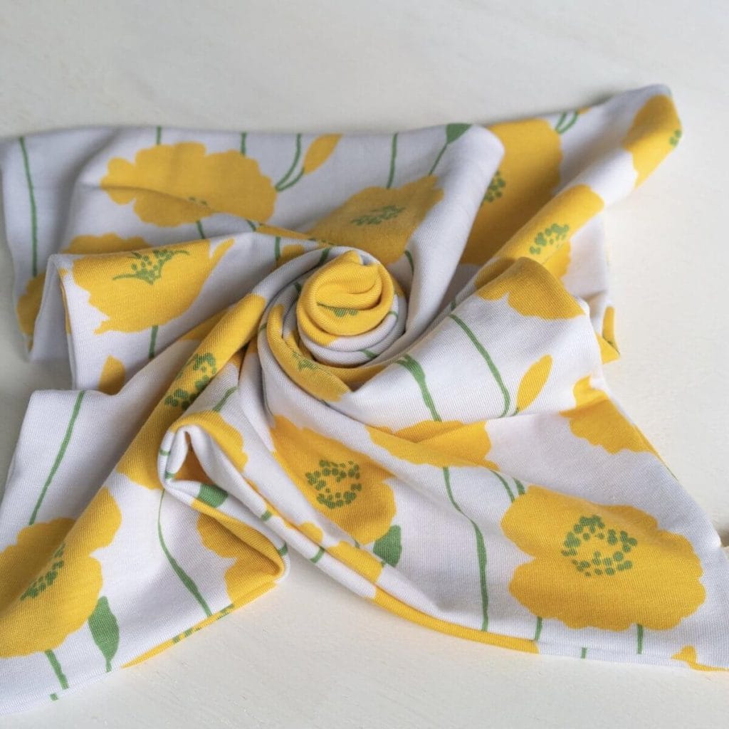 Soft blanket-like white fabric with yellow flowers on white background