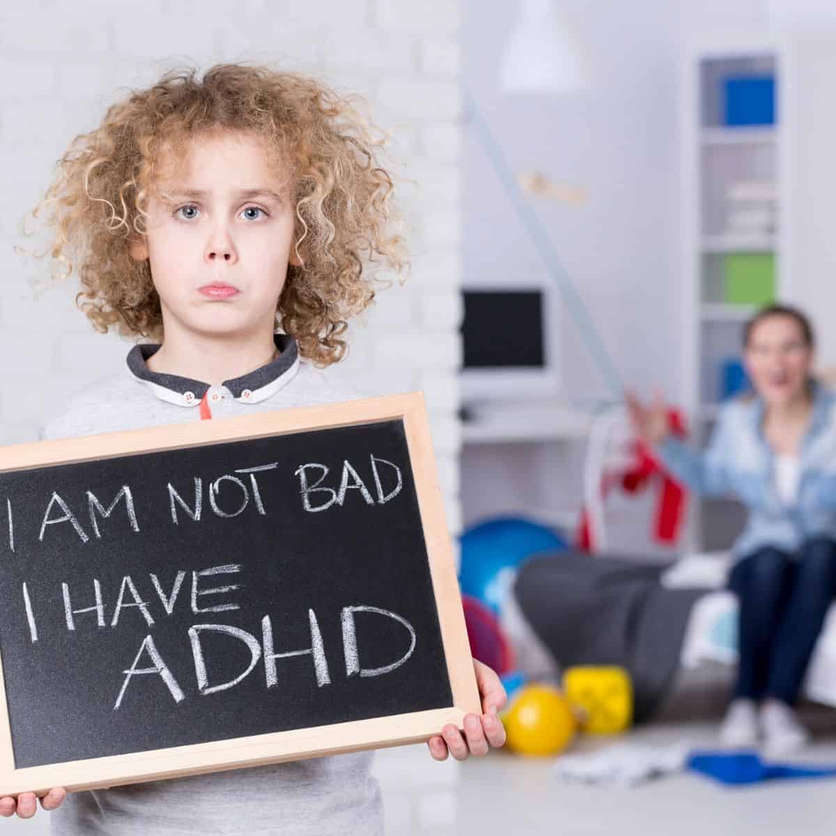 young boy holds sign that reads "I am not bad, I have ADHD"