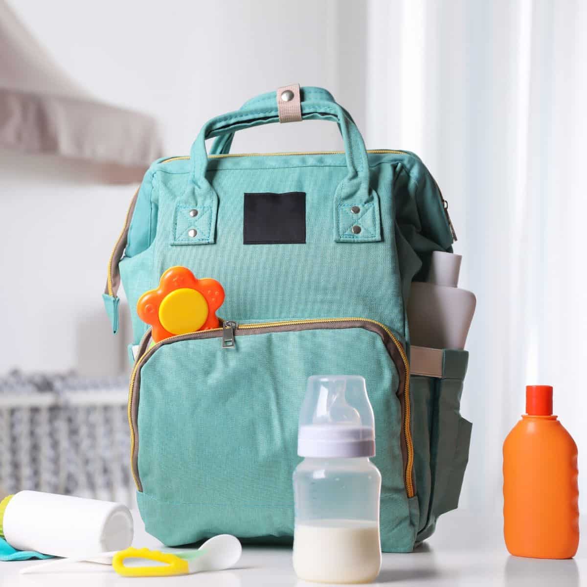diaper bag backpack surrounded by the essentials