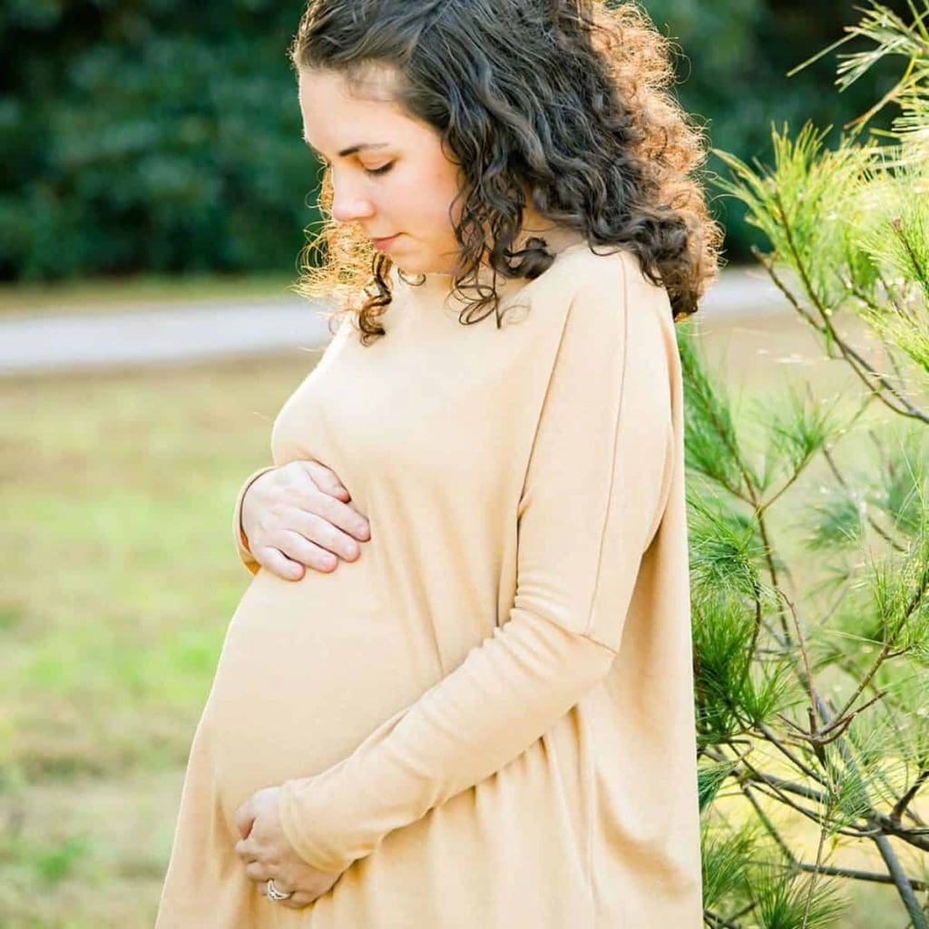Arden posing during a maternity photoshoot while she's in her third trimester with rainbow twins