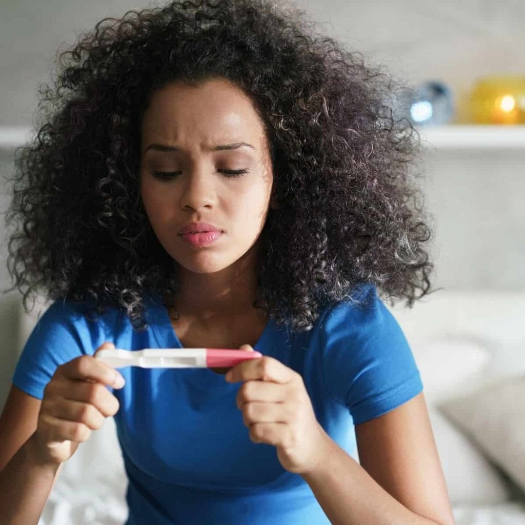 Woman nervously and anxiously checks her pregnancy test at the end of her two week wait