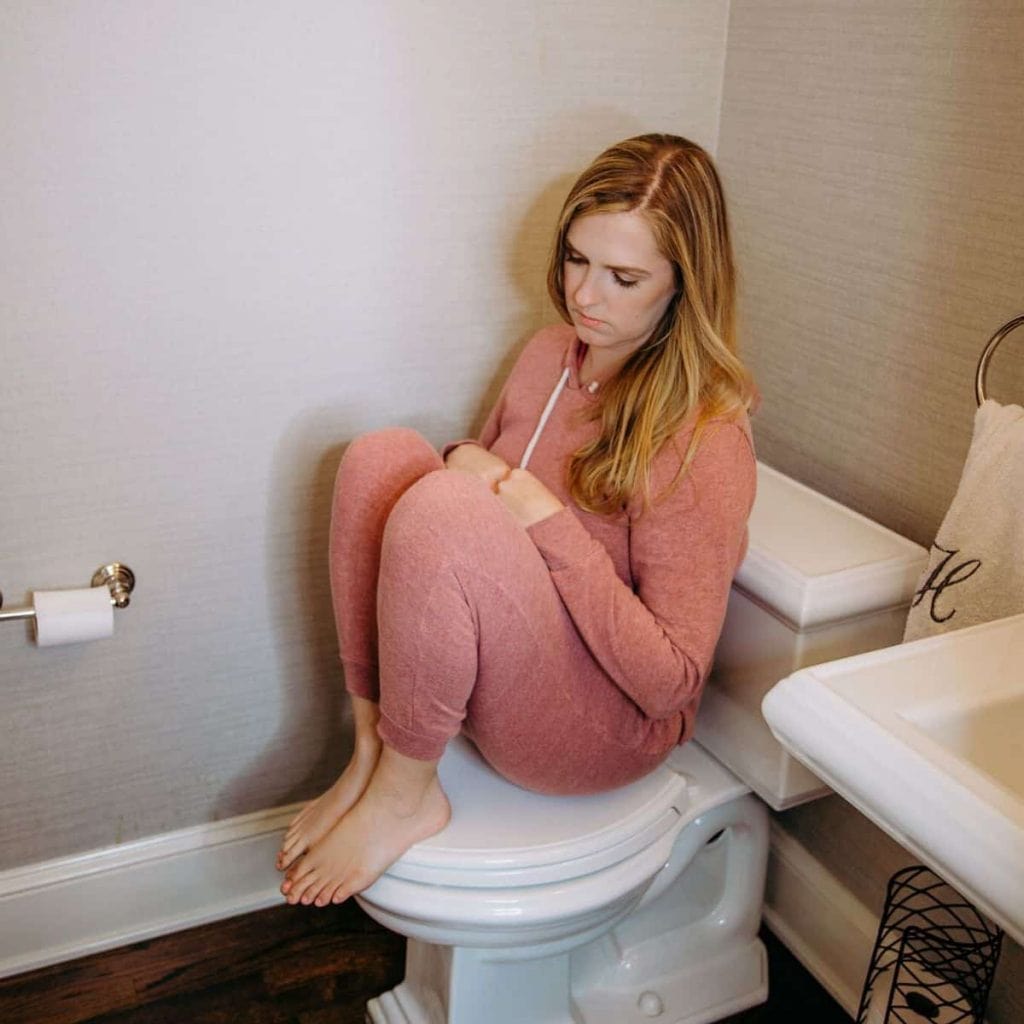 sad woman sitting in bathroom 