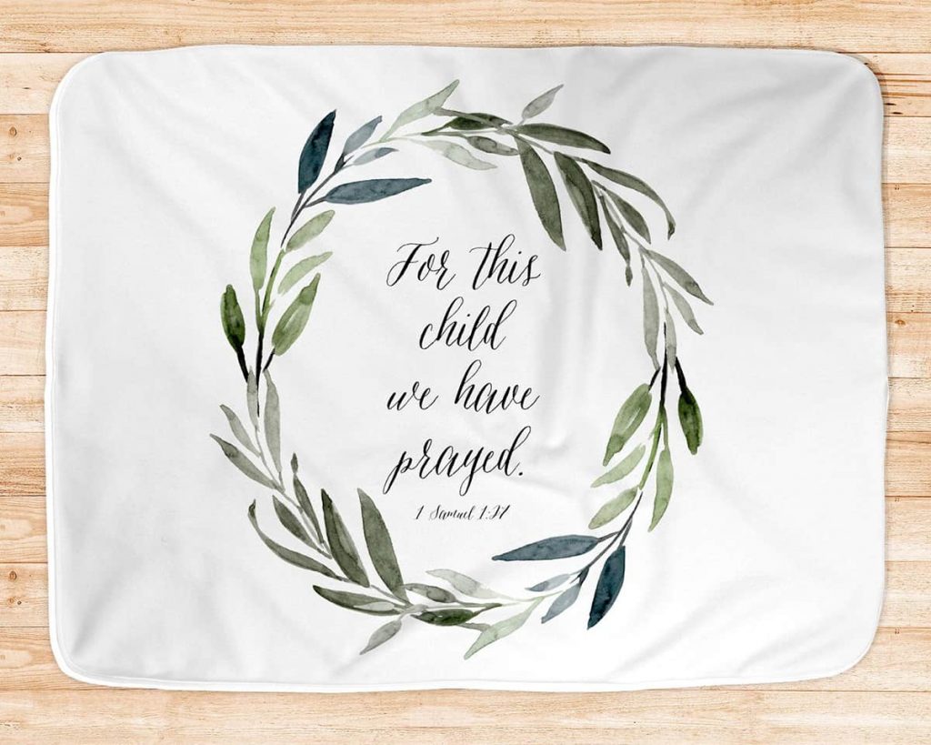 blanket with cursive texts that reads "For this child, we have prayed."