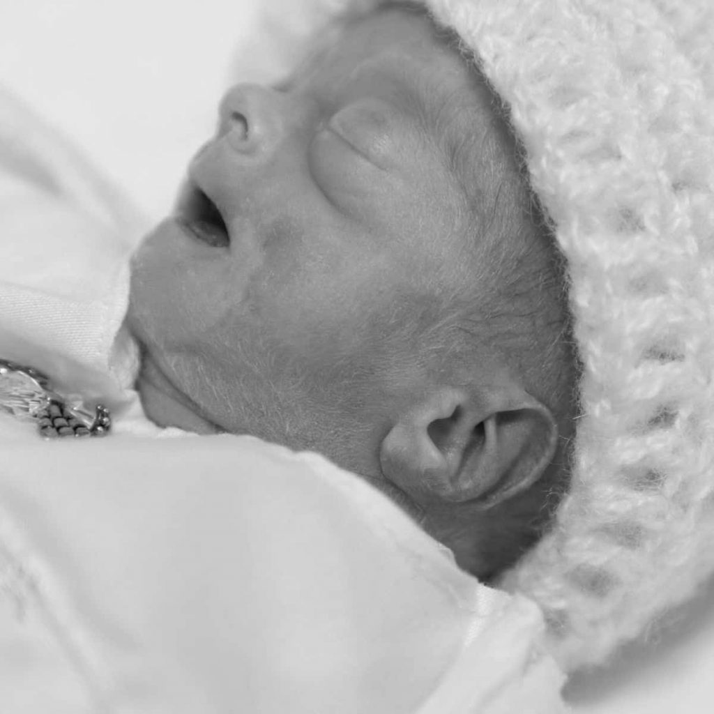 premature baby in white hat