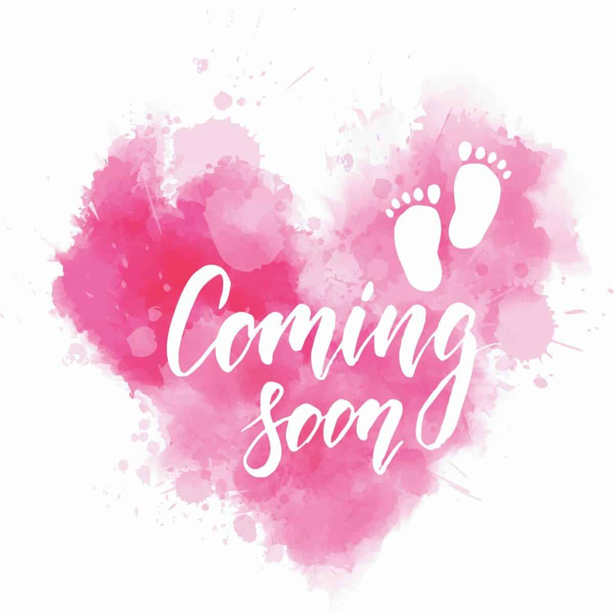 pink watercolor paint in the shape of a heart, with baby footprints and the words "coming soon"