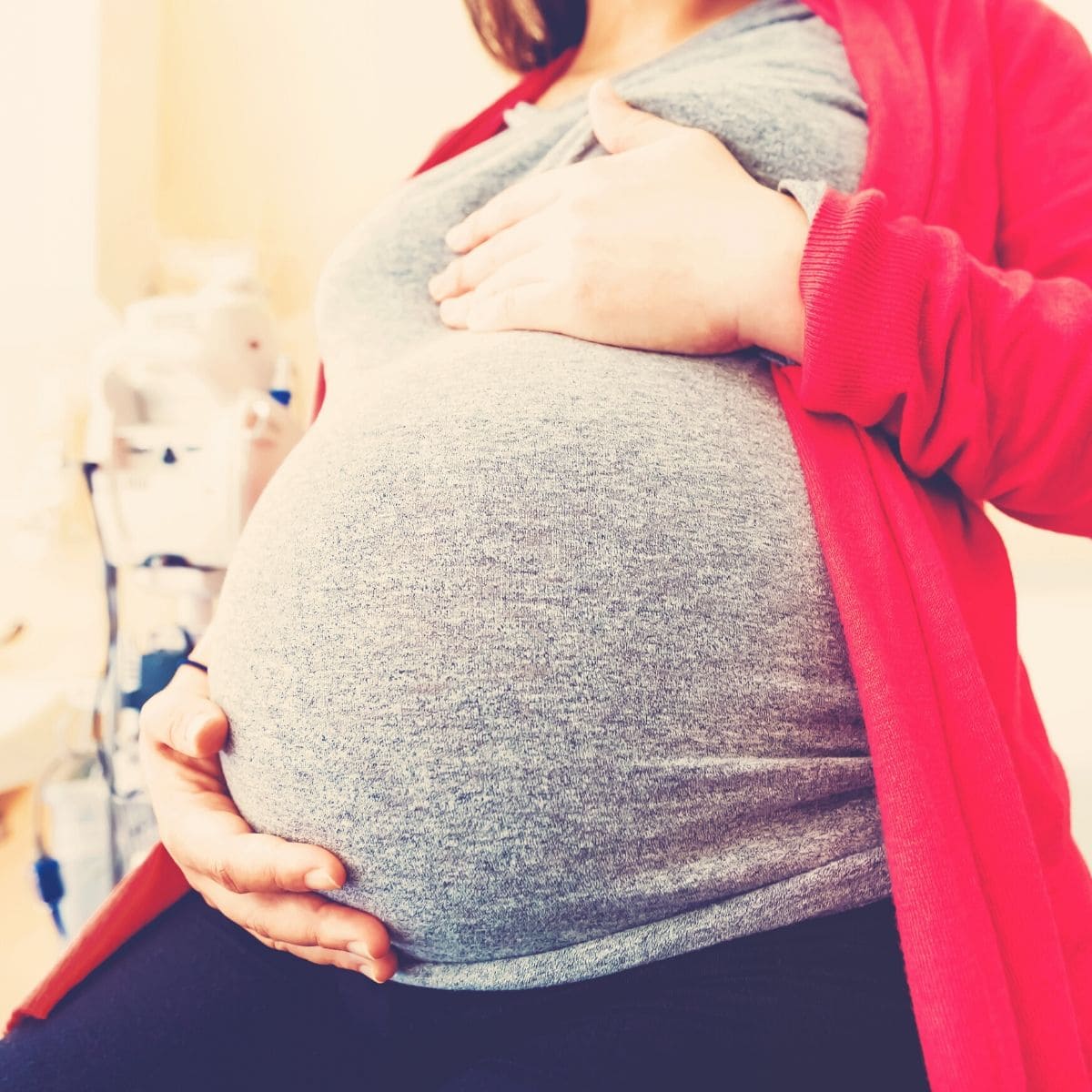 pregnant woman holding her belly with both hands