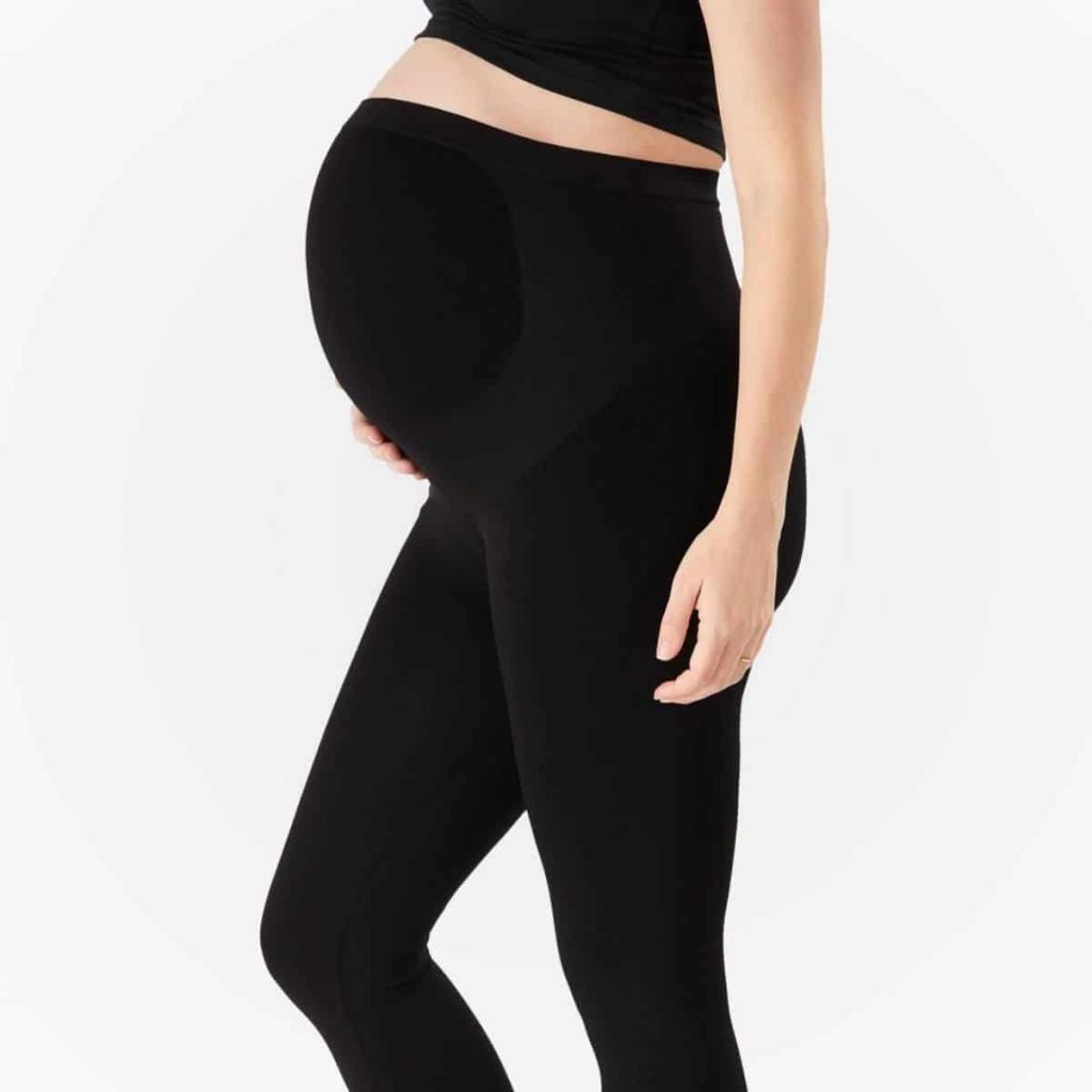 profile view of woman with pregnant belly wearing bump support maternity leggings