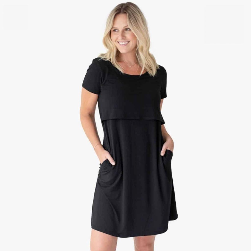 blonde woman standing in black maternity and nursing nightgown that doubles as a daytime dress
