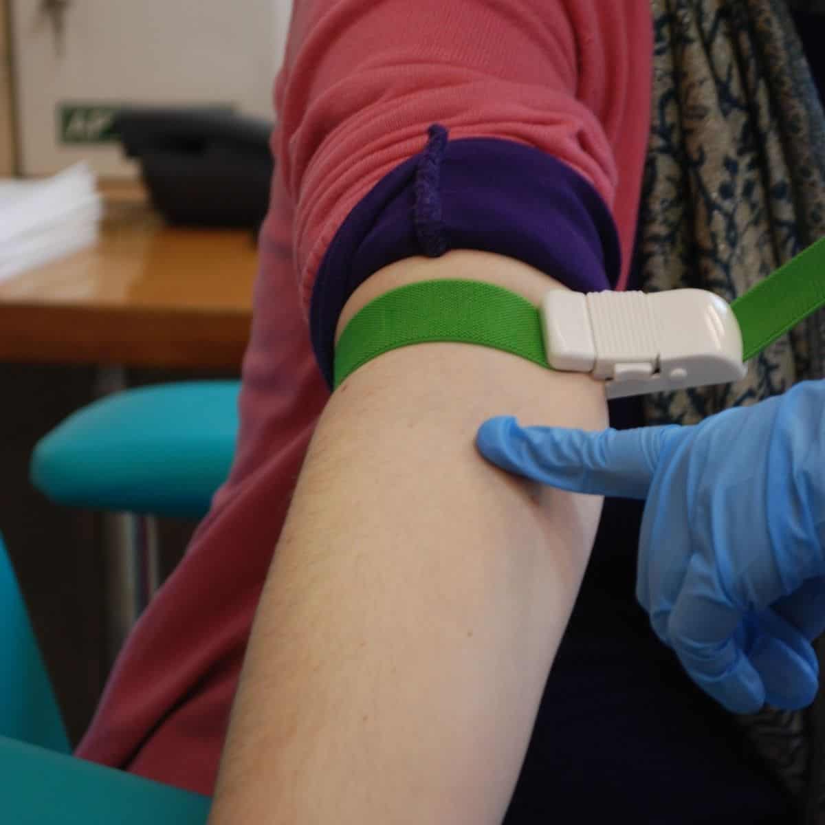 doctor preparing patient's forearm for fertility testing