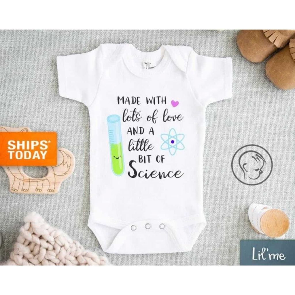a baby white onesie that reads "made with lots of love and a little bit of science"