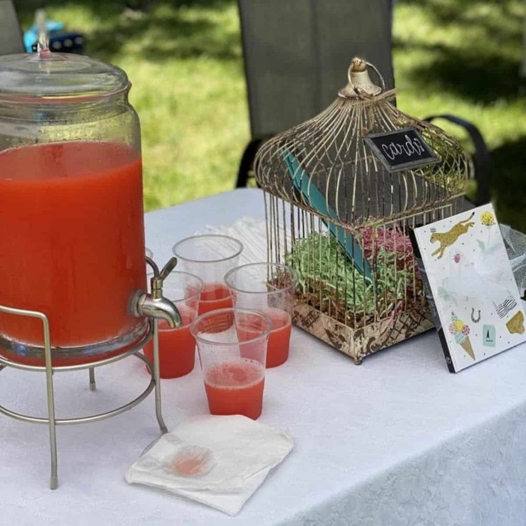 punch table with four cups of punch and decor for outdoor drive-by baby shower