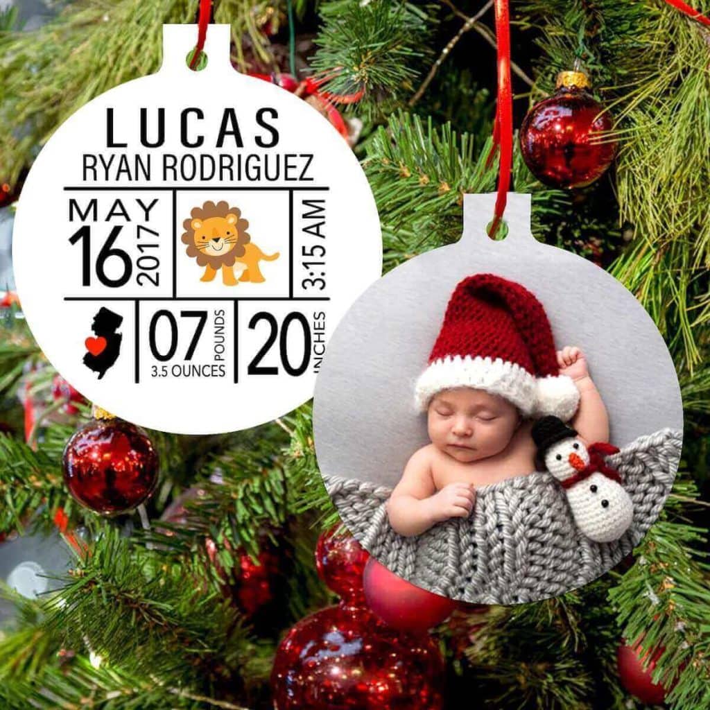 round Christmas ornament hanging on tree with the photo of a baby on the front and the baby's name and birth statistics on the back
