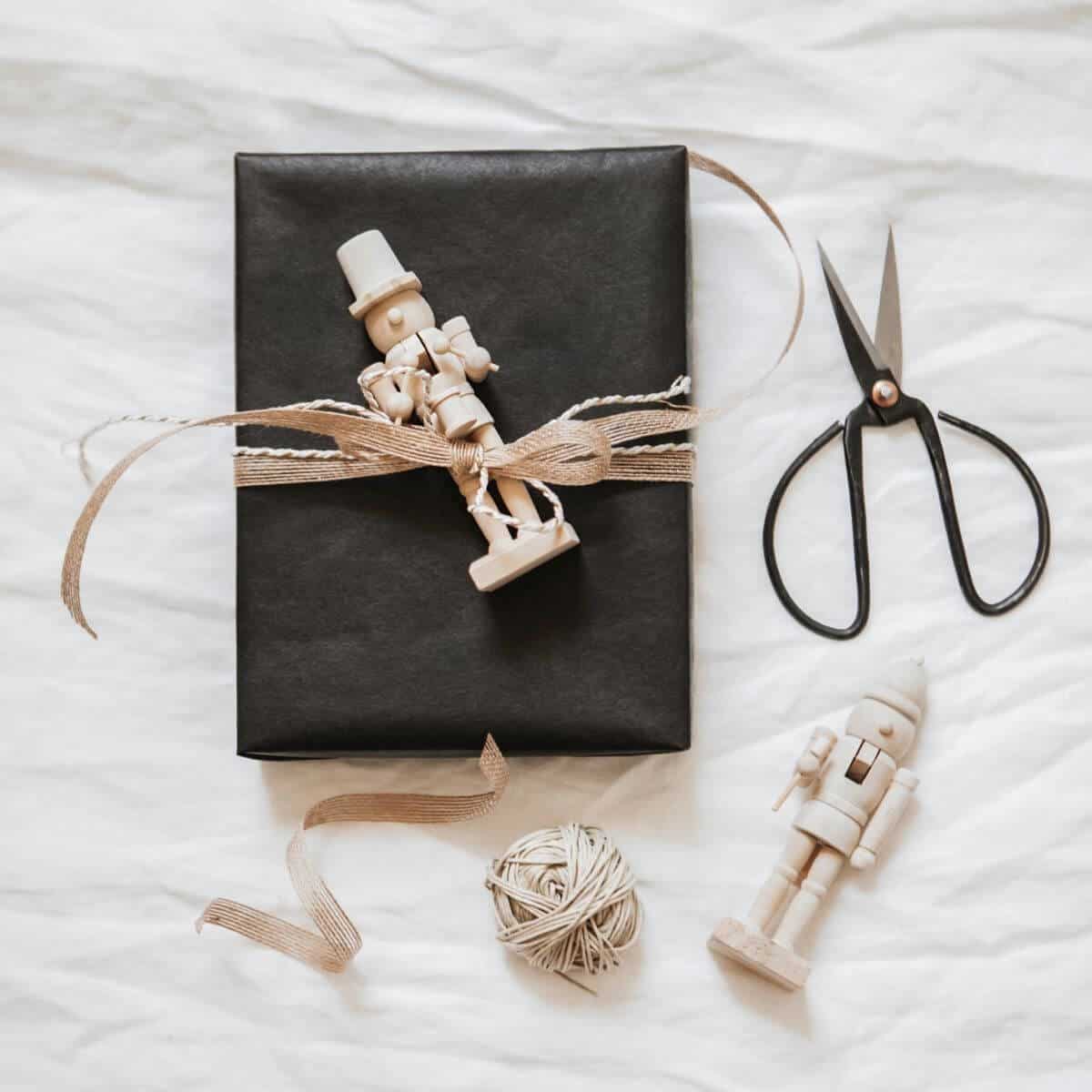 This image shows a black present tied up with a nutcracker and bow.