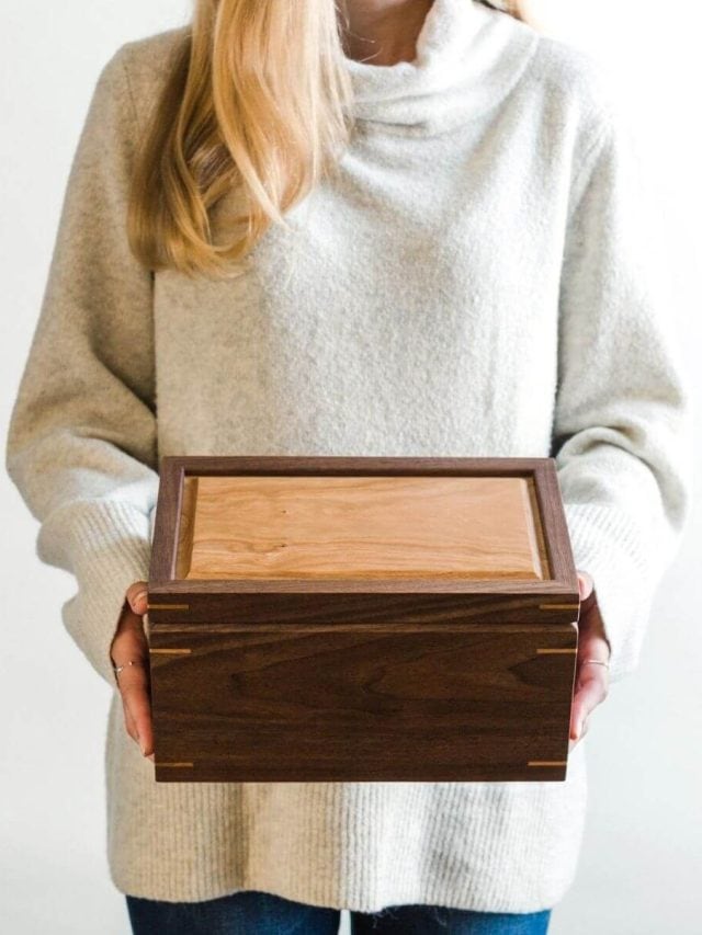 woman in cream colored sweater holding beautiful wooden keepsake box