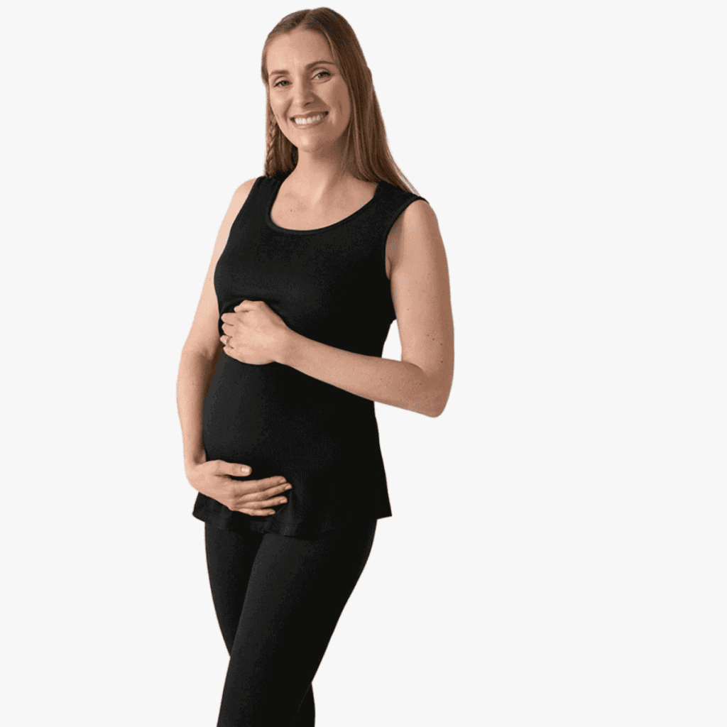 pregnant woman in tight black maternity pajamas holding her belly