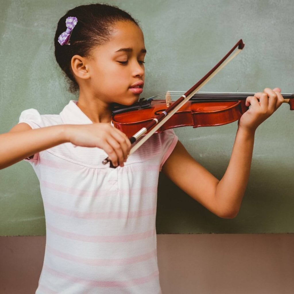 African American girl with a pink asnd white striped dress on playing a violin