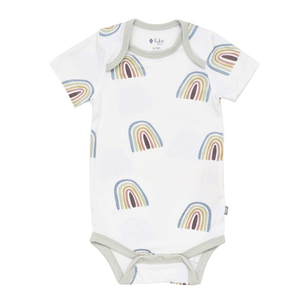 white onesie on with gray trim with pastel rainbows in blue, green, and brown