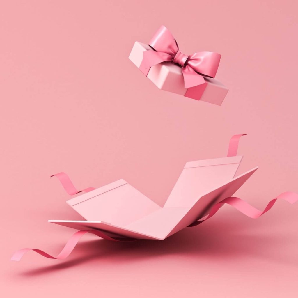 Pink background with a light pink box with the lid shooting in the air and the bottom part of the box broxen apart with the dark pink ribbon going everywhere