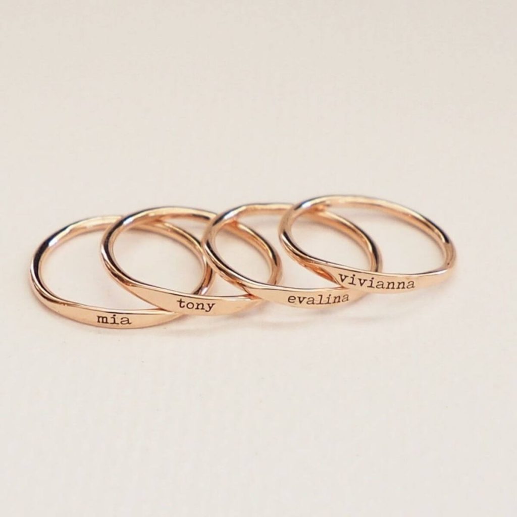 Four gold rings with the names Mia, Tony, Evalina, and Vivianna on them