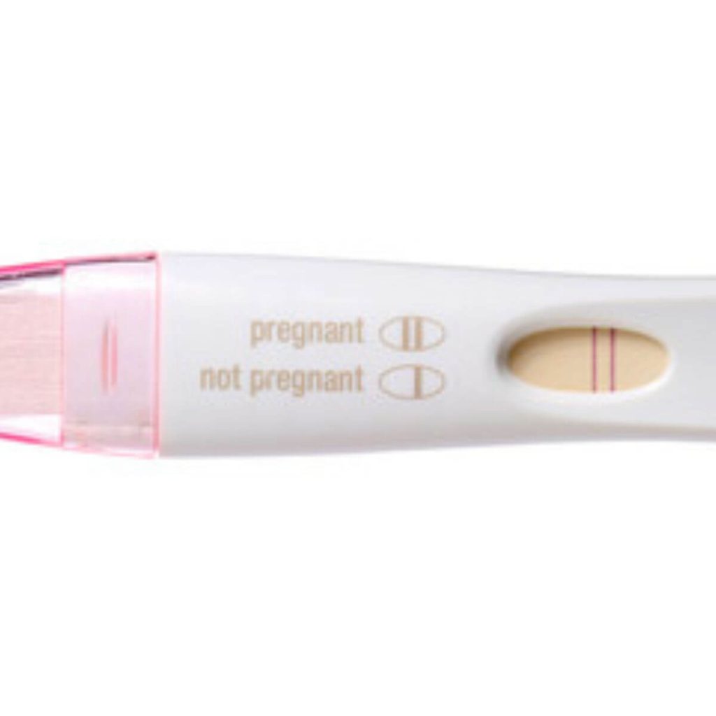 A pregnancy test with a light pink plastic top and white stick shows two lines for pregnant