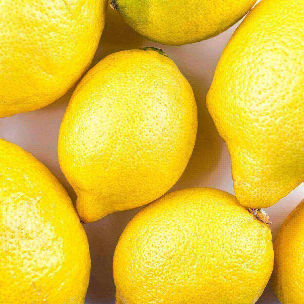 Seven bright yellow lemons are sitting on a table