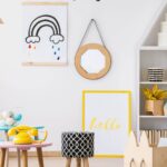 A vertical pin image that shows a playroom with a rainbow painting on the wall, cute little chairs with a yellow telephone on top, and a wooden storage bin that looks like a bunny. At the top it says Playroom Storage Ideas and there's a pink button at the bottom that says Click Here.
