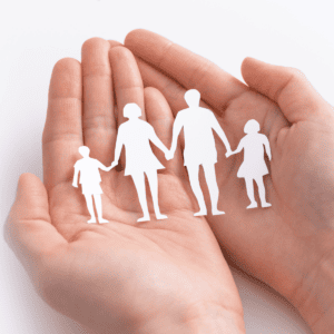 Two hands holding a paper cutout of a family holding hands