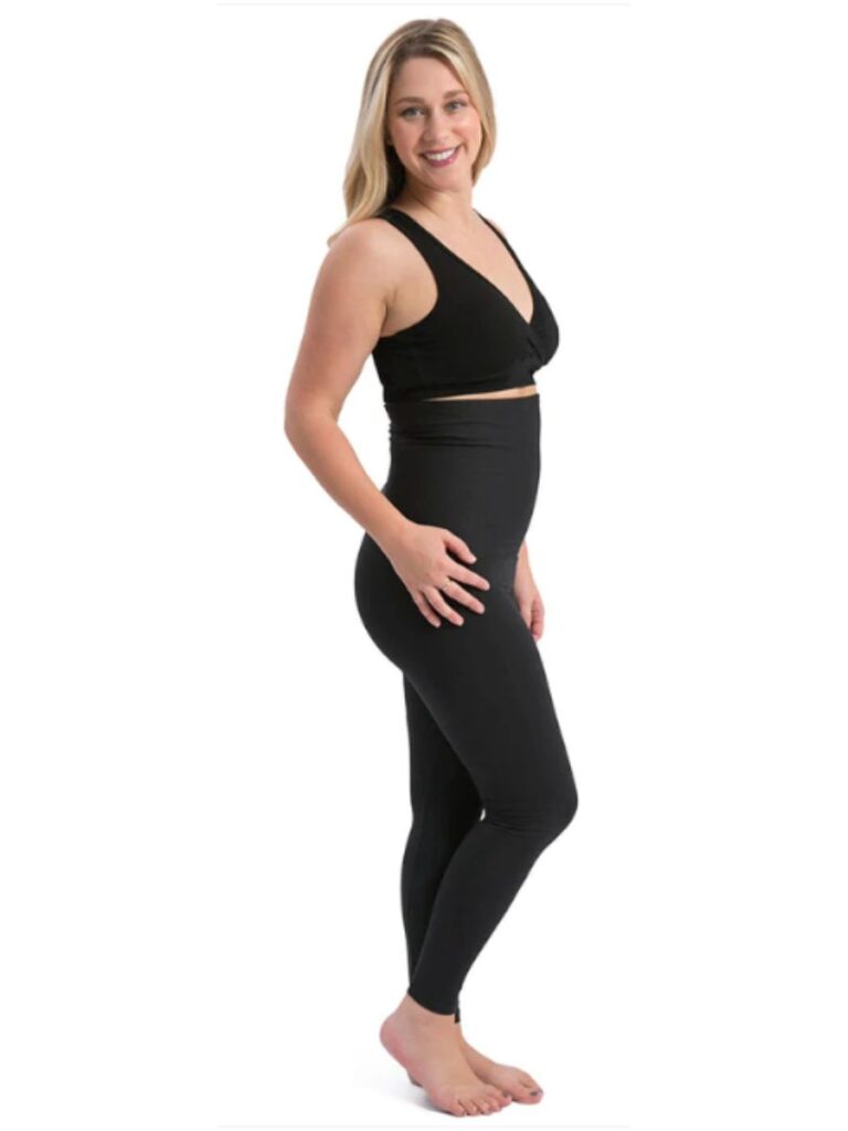 Woman wearing postpartum compression leggings and a black nursing bra